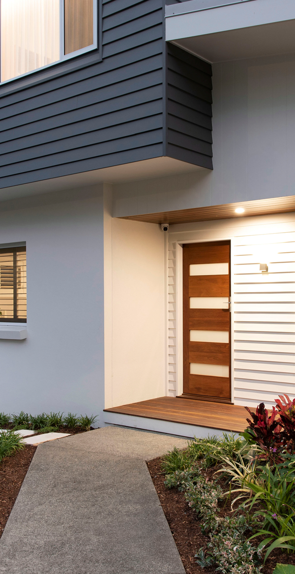 Modern entrance with wooden door and landscaped pathway
