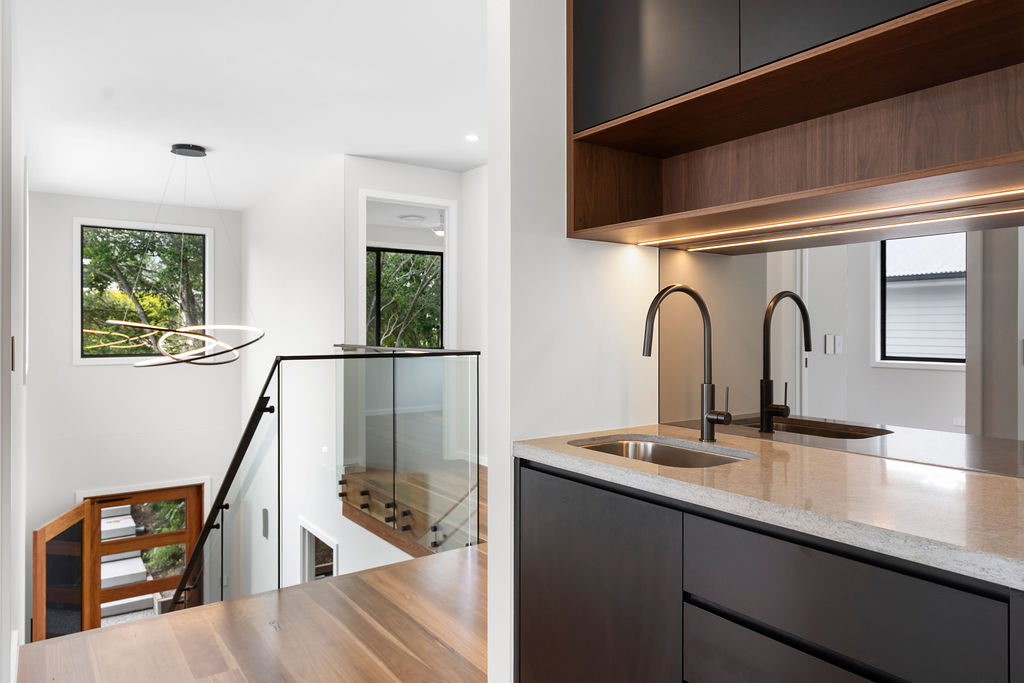 Modern interior with kitchen, glass railing, and pendant light